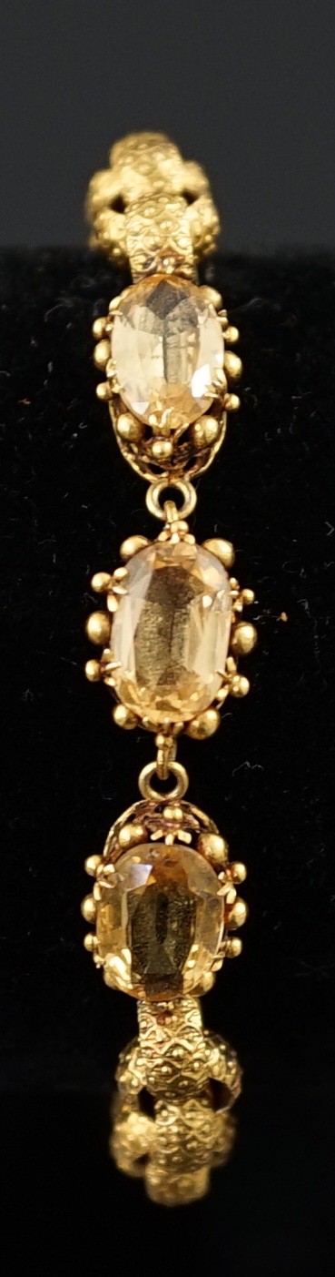 A 19th century cannetille work gold and four stone oval cut citrine set circular link bracelet